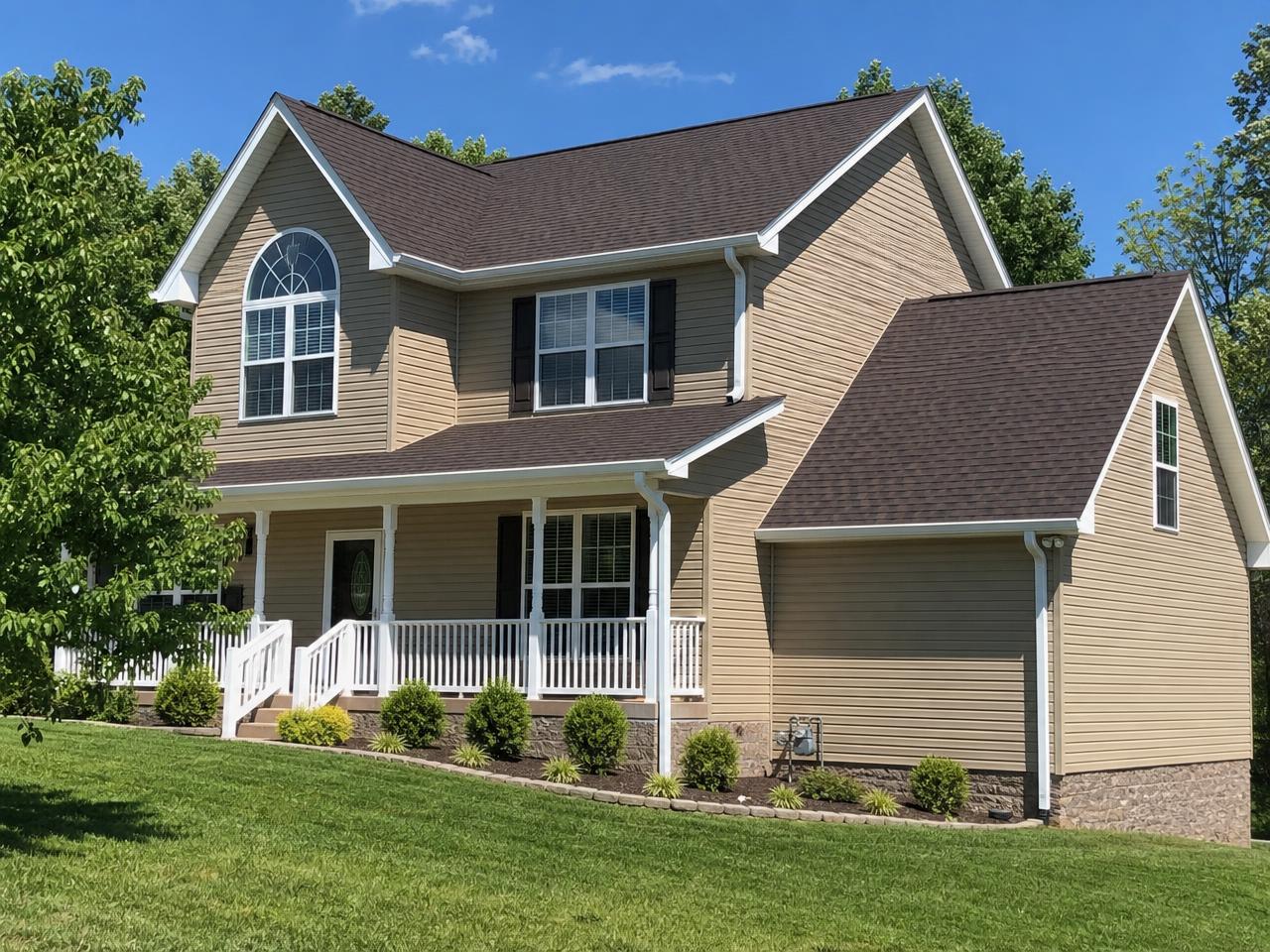 Two-story Tennessee home with a new brown architectural shingle roof and white gutters